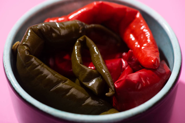 close up of pickled chili peppers in bowl on pink - Photo, Image