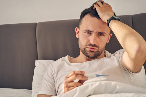 Brunette man staying at home, feeling sick - Photo, image