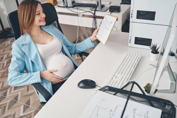 Joyful pregnant woman working in modern office - Fotoğraf, Görsel