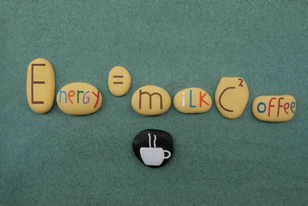 Einsteins Gleichung: Kaffeemacht mit kreativen Steinen über grünem Sand - Foto, Bild