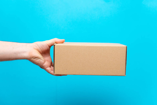 A man holds boxes in his hands on a blue background. Service delivery of goods. City delivery service. - Photo, Image