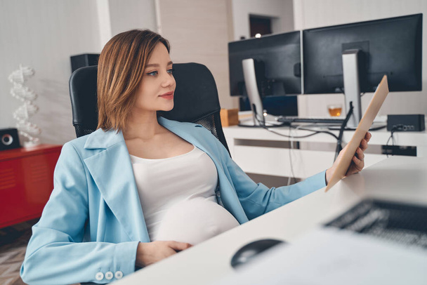Cute pregnant woman working in modern office - Fotó, kép