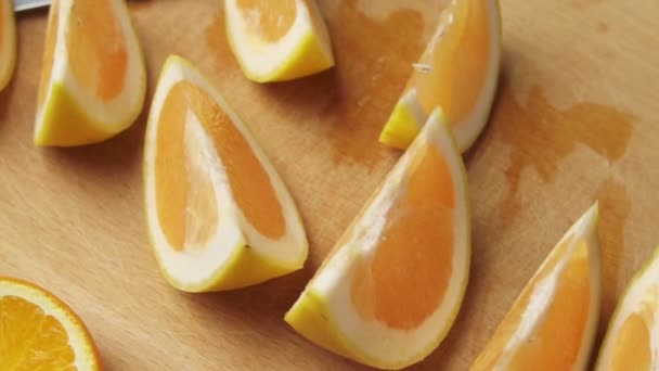 Fresh orange fruits on a wooden table, whole and sliced. A plate full of citrus slices.  - Πλάνα, βίντεο