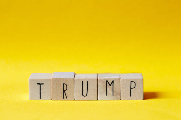 Ξύλινοι κύβοι με τη λέξη Trump σε πορτοκαλί φόντο, Πρόεδρος Αμερική έννοια - Φωτογραφία, εικόνα