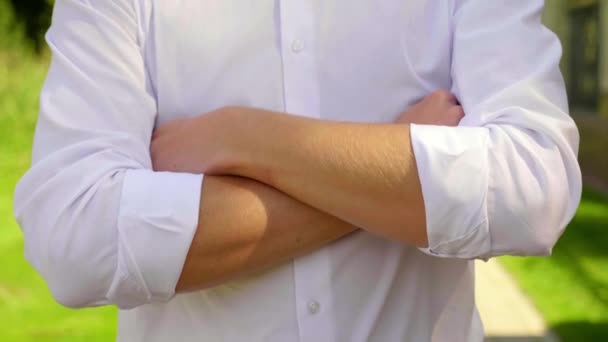 Close-up zakenman vouwt zijn armen over zijn borst en draait naar de camera - Video