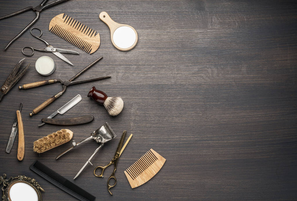Herramientas clásicas de aseo y peluquería sobre fondo de madera. Vista superior de los instrumentos de la barbería que ponen en la mesa de madera oscura. - Foto, imagen