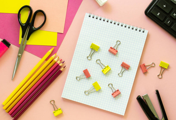 Various school and office supplies on a pink background - Фото, изображение