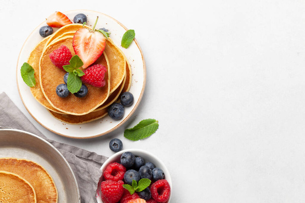 Вкусные домашние блинчики с летними ягодами на завтрак. Вид сверху с пространством для копирования
 - Фото, изображение