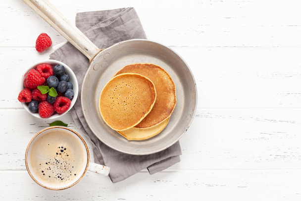 Delicious homemade pancakes with summer berries and coffee for breakfast. Top view with copy space - Foto, Imagem