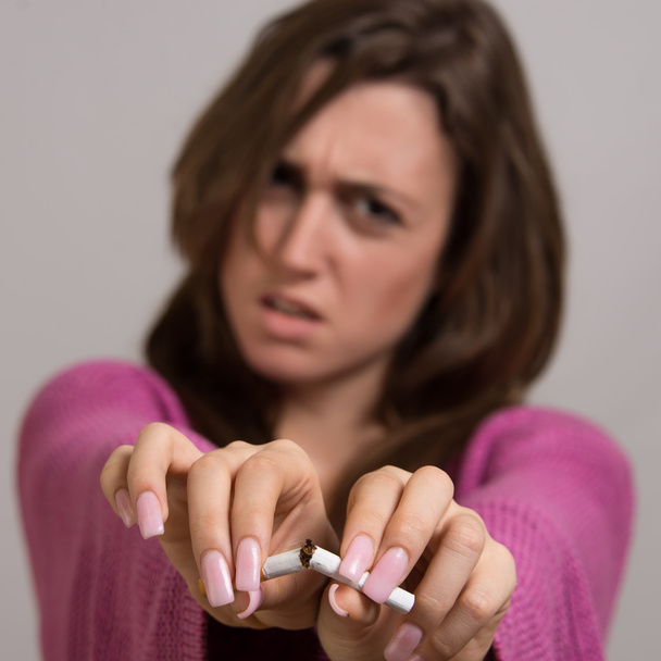 Porträt einer Frau, die sich eine Zigarette bricht - Foto, Bild
