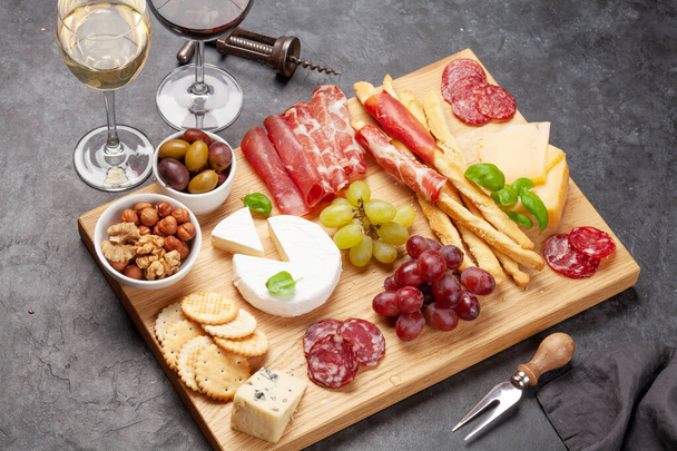 Juusto, liha, viinirypäleet ja oliivit antipasto. Alkupala valinta levy ja lasit puna- ja valkoviiniä
 - Valokuva, kuva