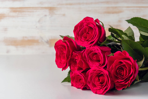 Bouquet of red roses on wooden table. Greeting card for Valentines Day, Womens Day. Holiday concept. - Foto, imagen