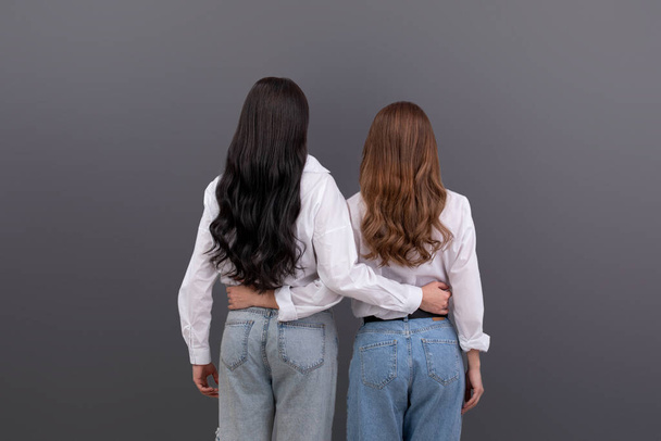 Back view of two unrecognizable women hugging each other. Friendship, family love concept. - 写真・画像