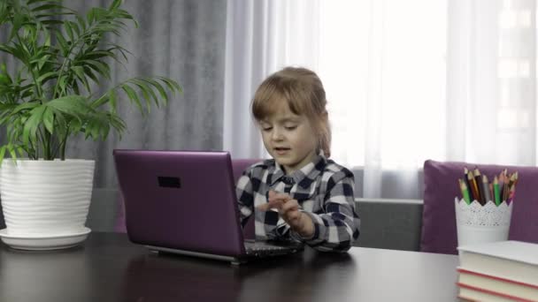 Tyttö opiskelee verkossa läksyjä digitaalisen kannettavan tietokoneen avulla. Etäopetus
 - Materiaali, video