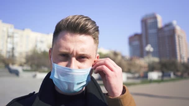 L'homme caucasien remet son masque médical dans la rue vide de la ville. Pandémie mondiale
 - Séquence, vidéo