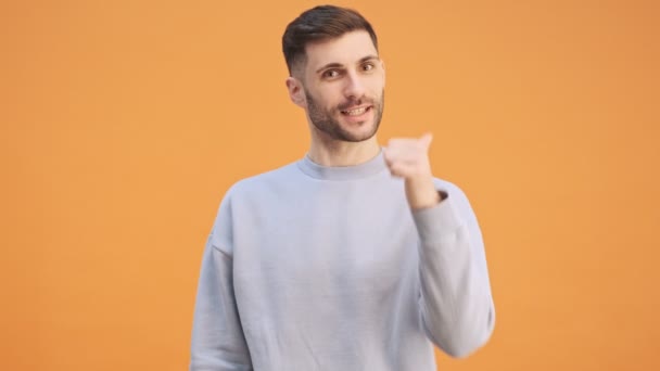 Fiatal boldog optimista férfi elszigetelt sárga fal háttér mutatja hüvelykujj fel - Felvétel, videó