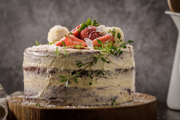 Naked cake with strawberries on kitchen counter top. - Фото, зображення