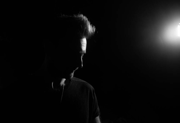 Dramatic profile portrait of male person on dark background - Photo, Image