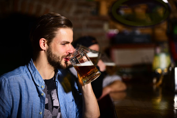 バーに座ってビールを飲む男。パーティーとお祝いのコンセプト - 写真・画像