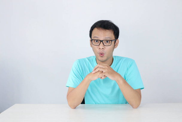 Wow and shocked face of Young Asian man with open hand gesture. Advertising model concept with blue shirt. - Photo, image