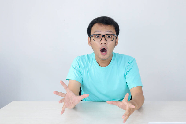 Wow and shocked face of Young Asian man with open hand gesture. Advertising model concept with blue shirt. - Φωτογραφία, εικόνα
