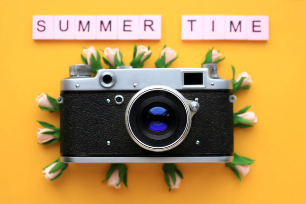 Old Retro film photo camera and the words Summer time, and flowers, on a yellow background. Summer concept. - Photo, Image