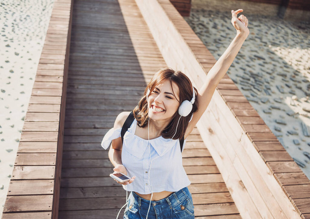 young girl with headphones using smartphone  outdoors - Foto, imagen
