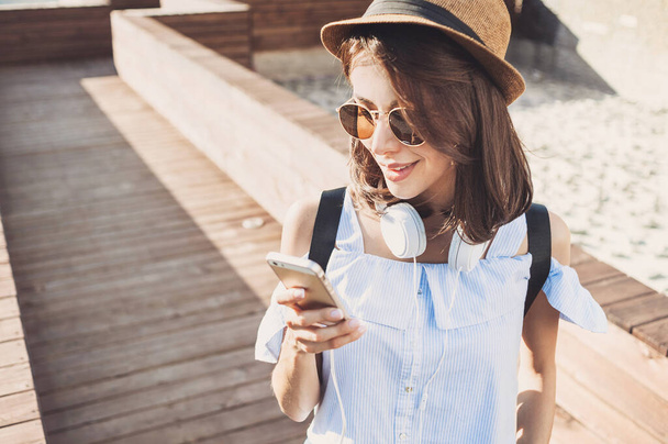 young girl with headphones using smartphone  outdoors - Photo, Image