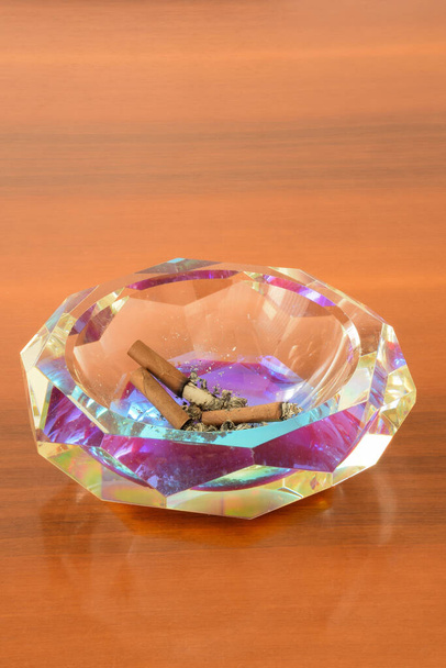Cendrier en cristal avec cigares sur une table en bois
 - Photo, image