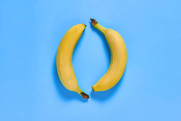 Pair of fresh ripe bananas on purple desk on kitchen. Healthy food concept. Top view. Close-up - Photo, image