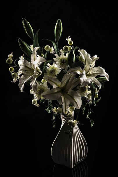Vase with decoration artificial lilys on black background - Valokuva, kuva