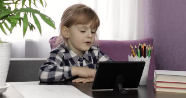 Dziewczyna robi pracę domową online za pomocą komputera cyfrowego tabletu. Edukacja na odległość - Materiał filmowy, wideo