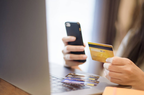 Женщина держит кредитную карту, делает покупки онлайн
  - Фото, изображение