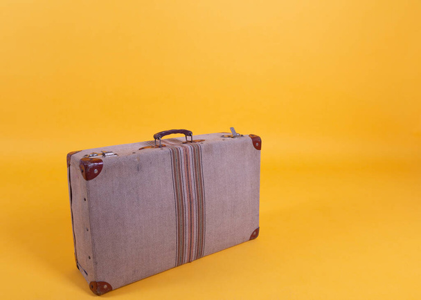 old suitcase on a yellow background, travel concept - Fotó, kép