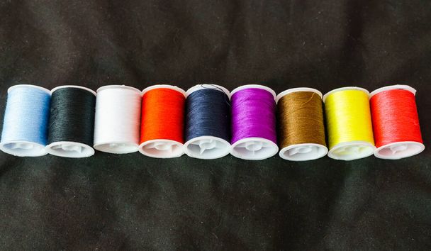 Bobines multicolores de fil gros plan sur un fond sombre
 - Photo, image