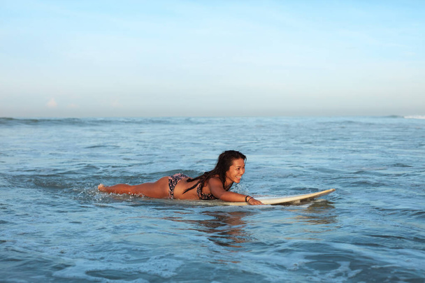 Sexy Surfer. Surfing Girl In Bikini On White Surfboard In Ocean. Tanned Brunette Swimming In Sea. Water Sport As Hobby.  - Fotografie, Obrázek
