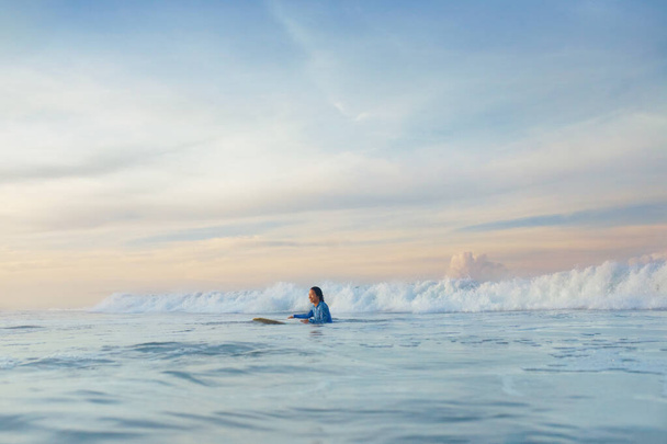 Surfing Girl. Surfer On Surfboard Swimming In Ocean. Surf In Blue Wetsuit Practicing In Sea. Water Sport For Active Lifestyle. - Foto, afbeelding