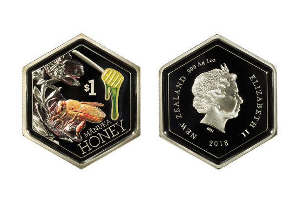 Una moneda de Nueva Zelanda de $1 "Manuka Honey" de 2018, hecha de 1 onza de plata. Está en una forma hexagonal inusual como las células de un panal y cuenta con color selectivo en la abeja y la miel dipper
 - Foto, imagen