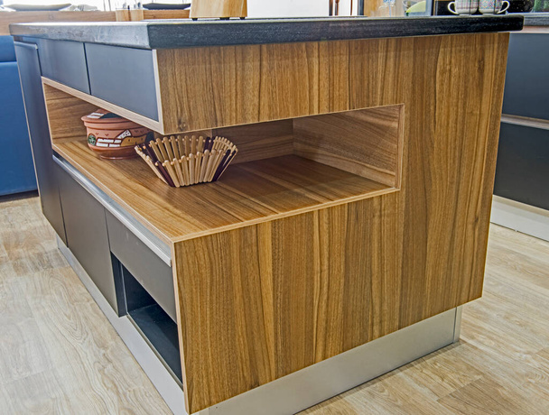 Decoración de diseño interior que muestra la isla de la cocina moderna con estante de madera en lujoso apartamento showroom
 - Foto, imagen