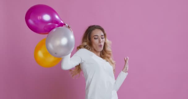 Happy young woman dancing with bunch of air balloons - Video, Çekim