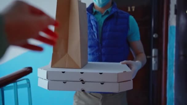 POV bezorger komt naar appartement en geeft bestelling, papieren pakket en pizza dozen. - Video