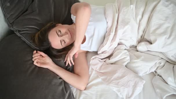 Houkutteleva hymyilevä nuori nainen venyttely sängyssä herääminen yksin onnellinen konsepti, hereillä jälkeen terveellisen unen viihtyisä mukava sänky ja patja nauttia hyvää huomenta
 - Materiaali, video