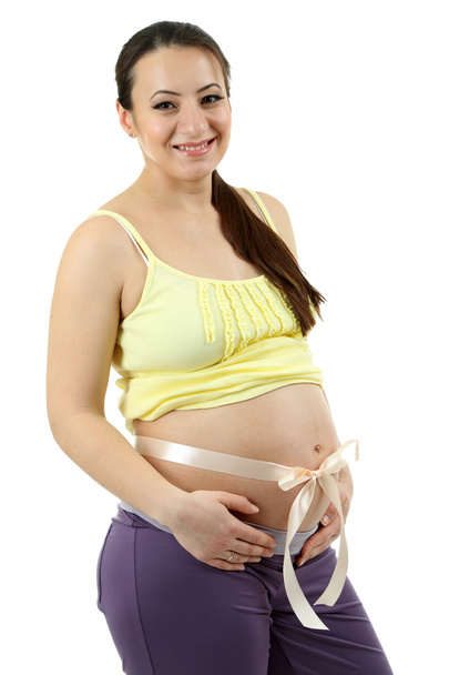 Young pregnant woman with beige bow on belly isolated on white - Foto, imagen