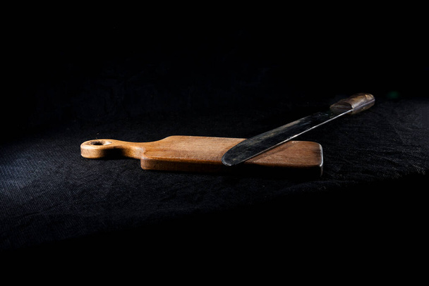 Mačeta na dřevěném stole na černém izolovaném pozadí - Fotografie, Obrázek