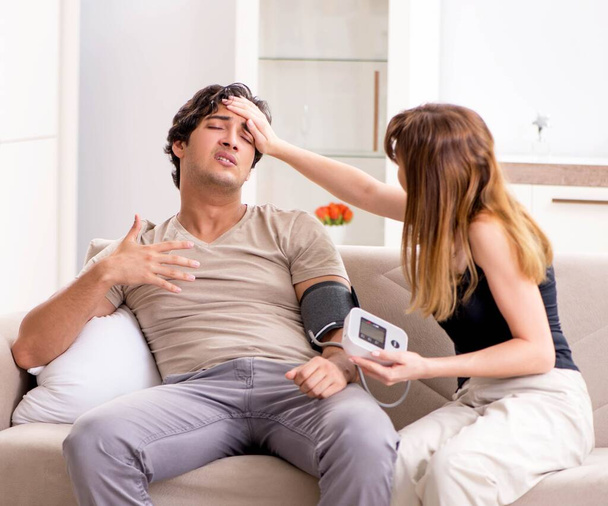 Wife checking husbands blood pressure - Photo, Image