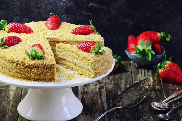Torta al miele con fragola sul banco della torta. Torta fatta in casa taglio e fetta
 - Foto, immagini