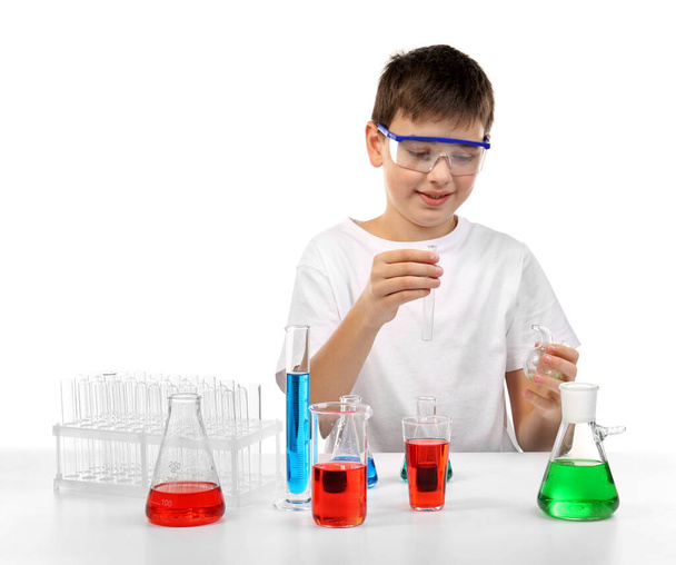 Zeki küçük çocuk beyaz üzerinde izole edilmiş kimyasal deneyler yapıyor. - Fotoğraf, Görsel