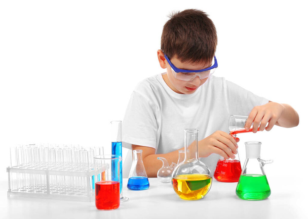 Fiksu pikkupoika tekemässä kemiallisia kokeita, eristyksissä valkoisella
 - Valokuva, kuva