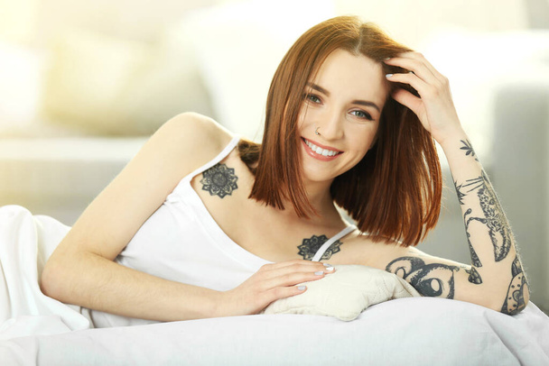 Attractive woman with tattoo lying on the bed - Photo, Image