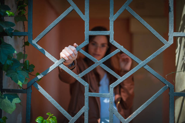 Krásná mladá žena za kovovými mřížemi rozmazané - Fotografie, Obrázek